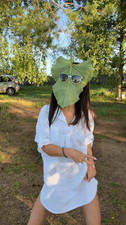 Leaf held over face in a Russian wooded park