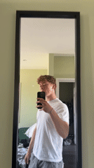 Young man films himself in mirror in London