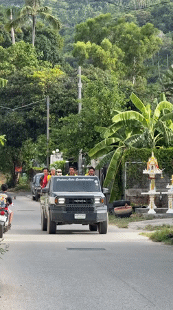 Trucks and a scooter moving through Ko Samui streets