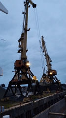 Port cranes operate at dusk in Bol'shie Mkhi, Russia
