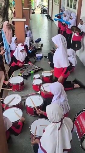 Uniformed ensemble rehearses music in an Indonesian outdoor walkway