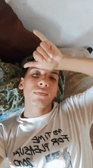 Person displays various expressions while relaxing in bedroom