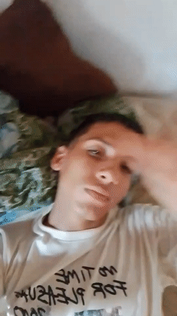 Person displays various expressions while relaxing in bedroom