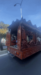 Ornate dragon-carved wooden structure transported by truck in Vietnam