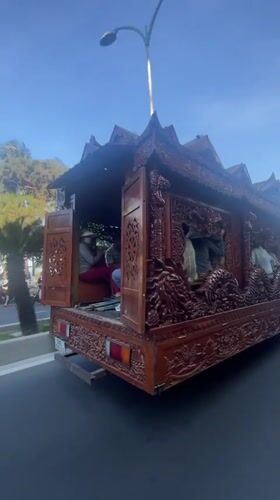 Ornate dragon-carved wooden structure transported by truck in Vietnam
