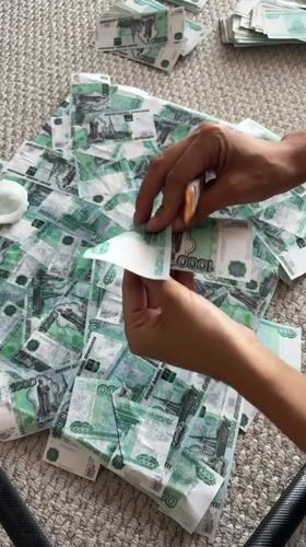 Person processes Russian banknotes with tools in Krasnoyarsk residence