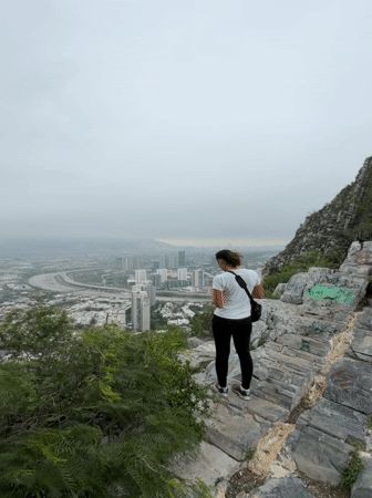 Woman views Santa Catarina cityscape from mountain overlook