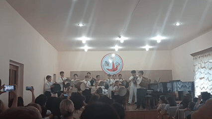 Student drum ensemble performs on stage at a youth event