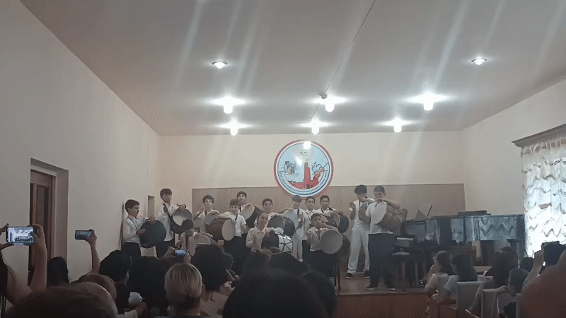 Student drum ensemble performs on stage at a youth event