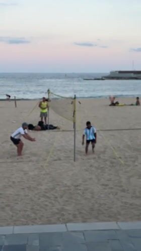 Barcelona beachgoers enjoy evening activities at Port Olímpic waterfront