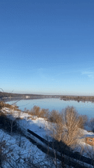 Woman stands by frozen Istra River in winter Russia