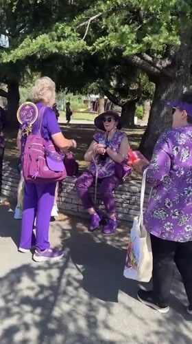 Purple-clad women gather at Bar Montenegro plaza near tour buses