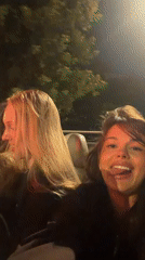 Women recorded making playful gestures in nighttime vehicle, Moscow