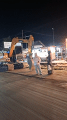 Excavator parked near roadside eatery in Lhokseumawe, Indonesia