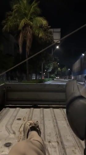Person rides in pickup truck bed through North Jakarta streets