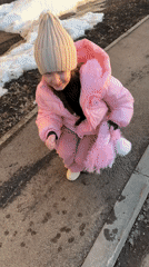 Children pet stray cat on wet street in Russia
