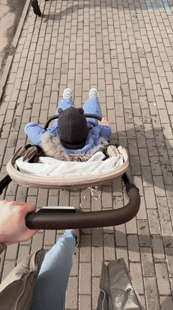 Woman pushes baby stroller on morning walk in Khimki