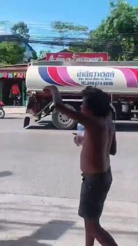Barefoot on a Ko Samui sidewalk, arm raised near traffic light