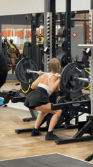 Woman performs barbell squats at gym in Chaikovsky, Russia