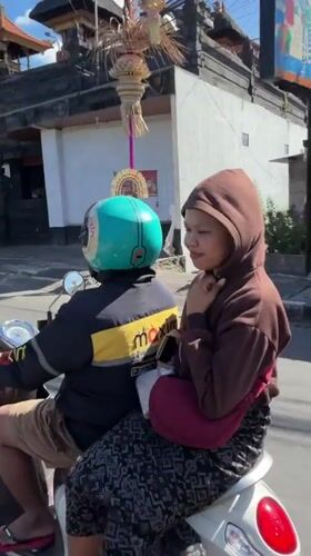 White motorcycle with two riders on a North Kuta street