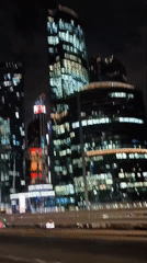 Nighttime city drive ending at a bar, glass towers throughout