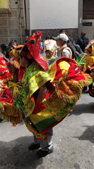 Children in colorful costumes perform street parade dance