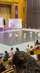Young dancers perform synchronized routine in white dresses