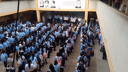 Students gather for assembly with sign-holders in Venezuelan school courtyard