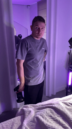 Photographer with camera observed in violet-lit room in Izhevsk