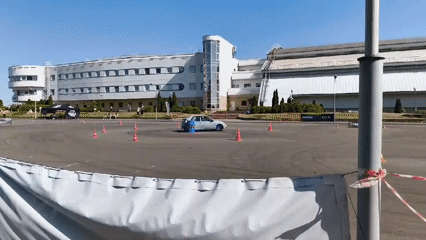 Cars sliding through cones at an outdoor drifting event