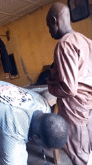 Men conduct clothing measurements in Sabon Tasha indoor setting