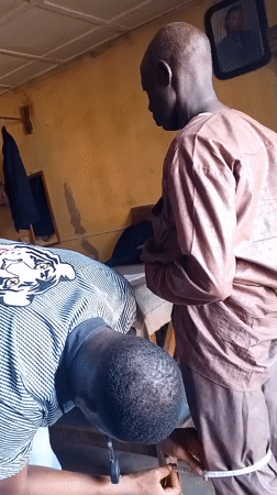 Men conduct clothing measurements in Sabon Tasha indoor setting