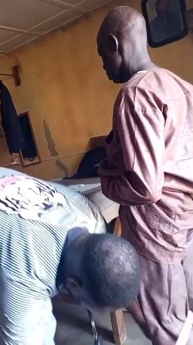 Men conduct clothing measurements in Sabon Tasha indoor setting