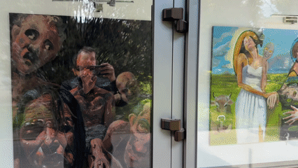 Art display observed behind glass doors in Târgu Mureș