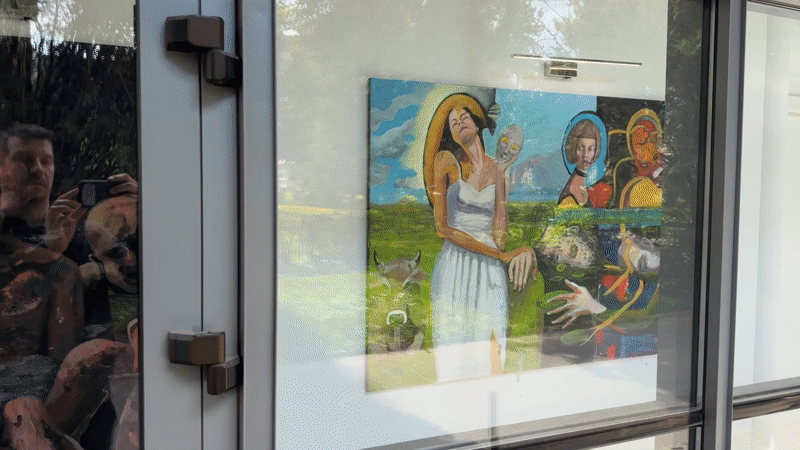 Art display observed behind glass doors in Târgu Mureș