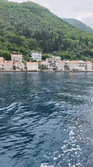 Tourist boats film scenic Montenegro coastal villages during morning cruise