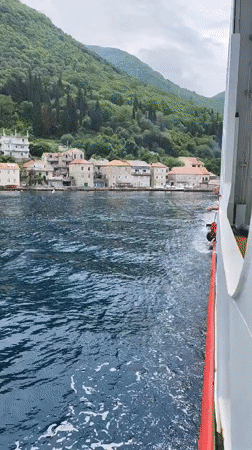 Tourist boats film scenic Montenegro coastal villages during morning cruise