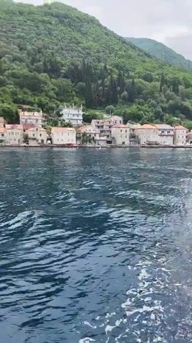Tourist boats film scenic Montenegro coastal villages during morning cruise