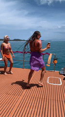 Dancing on a boat deck off Ko Samui, phone in hand