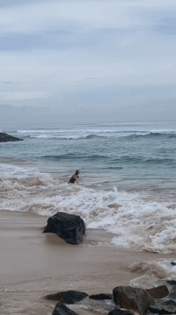 Early morning surfer rides waves at Sri Lankan beach