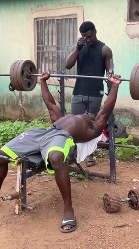 Man bench presses weights in Akwanga, Nigeria