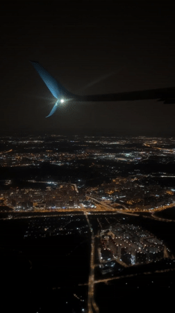 Nighttime aerial view captures illuminated city from aircraft over Vnukovo