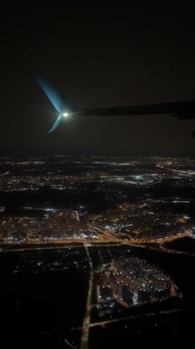 Nighttime aerial view captures illuminated city from aircraft over Vnukovo