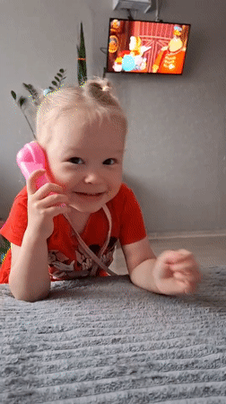 Children play with toy phone, tend to baby in Russian home
