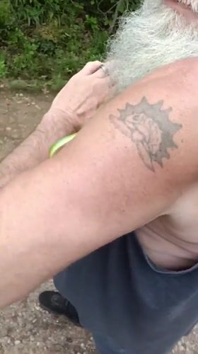 Bearded man handles green snake with children in Park Hill