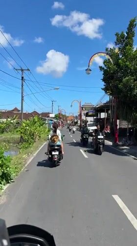 Moped riders travel through Gianyar street in early morning