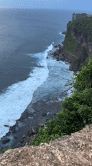 Tourist takes clifftop selfies overlooking ocean in Kuta Selatan