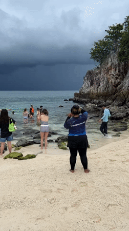 Stormy skies over a packed tourist beach in Phru Nai
