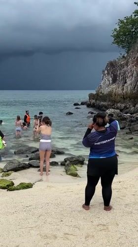 Stormy skies over a packed tourist beach in Phru Nai