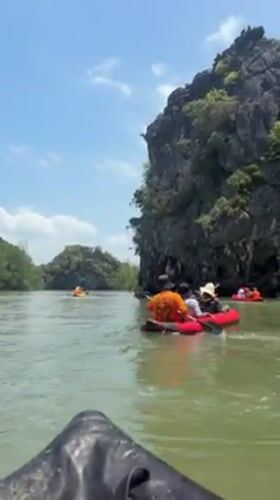 Kayakers explore limestone karsts and mangroves in Krasom Thailand